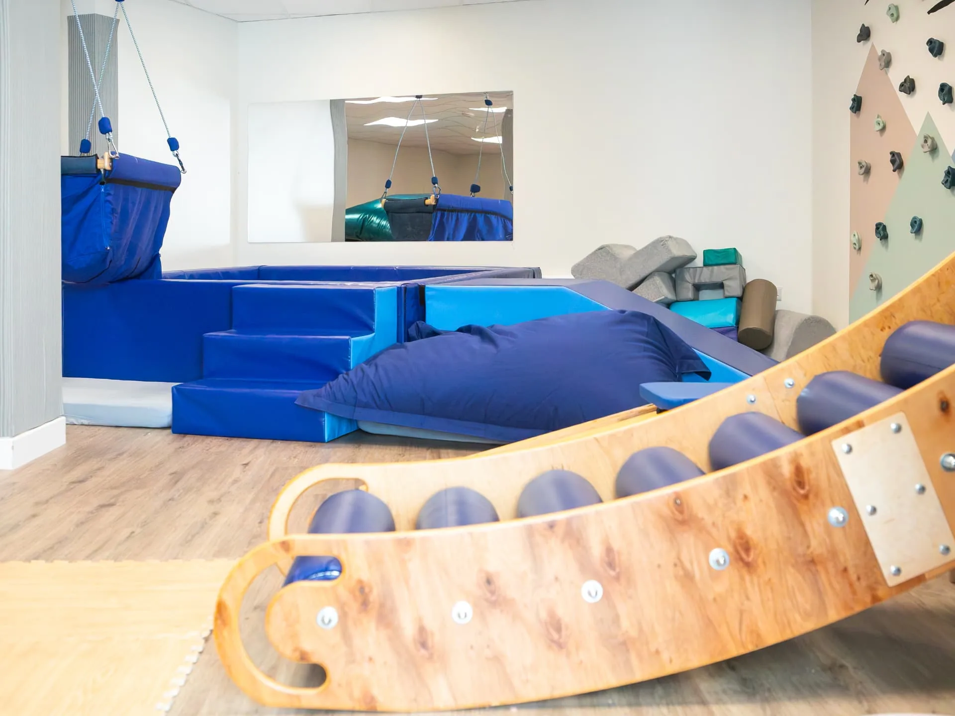 The Connect soft play room with a therapy swing, crash mats, a climbing wall and a wooden roller slide