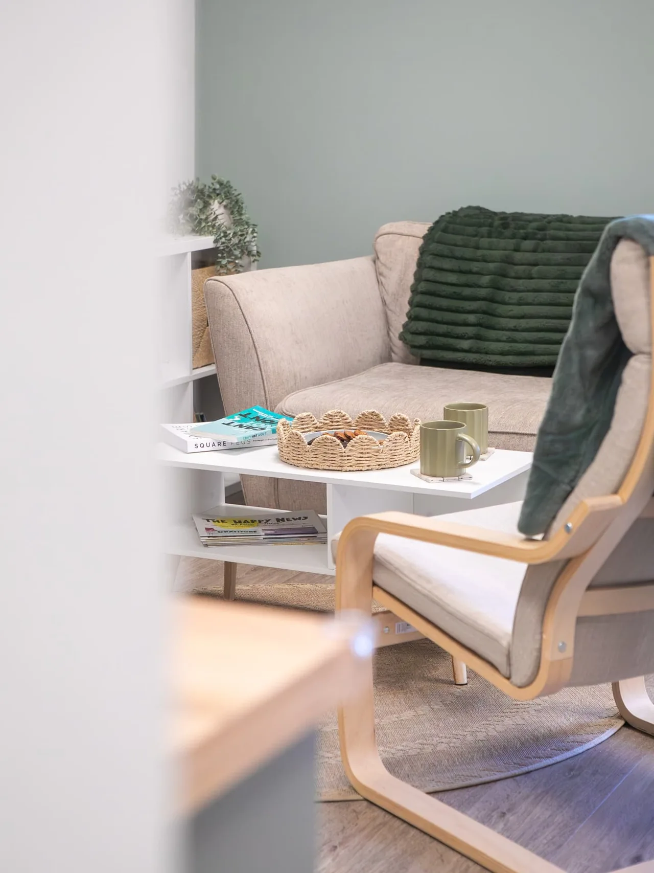 The Connect therapy room with a green sofa, coffee table and bookshelves