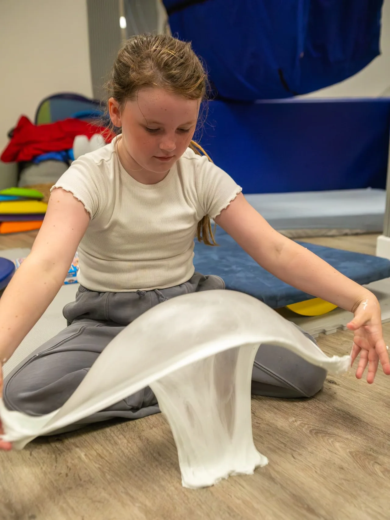 A girl stretching pale slime between her hands