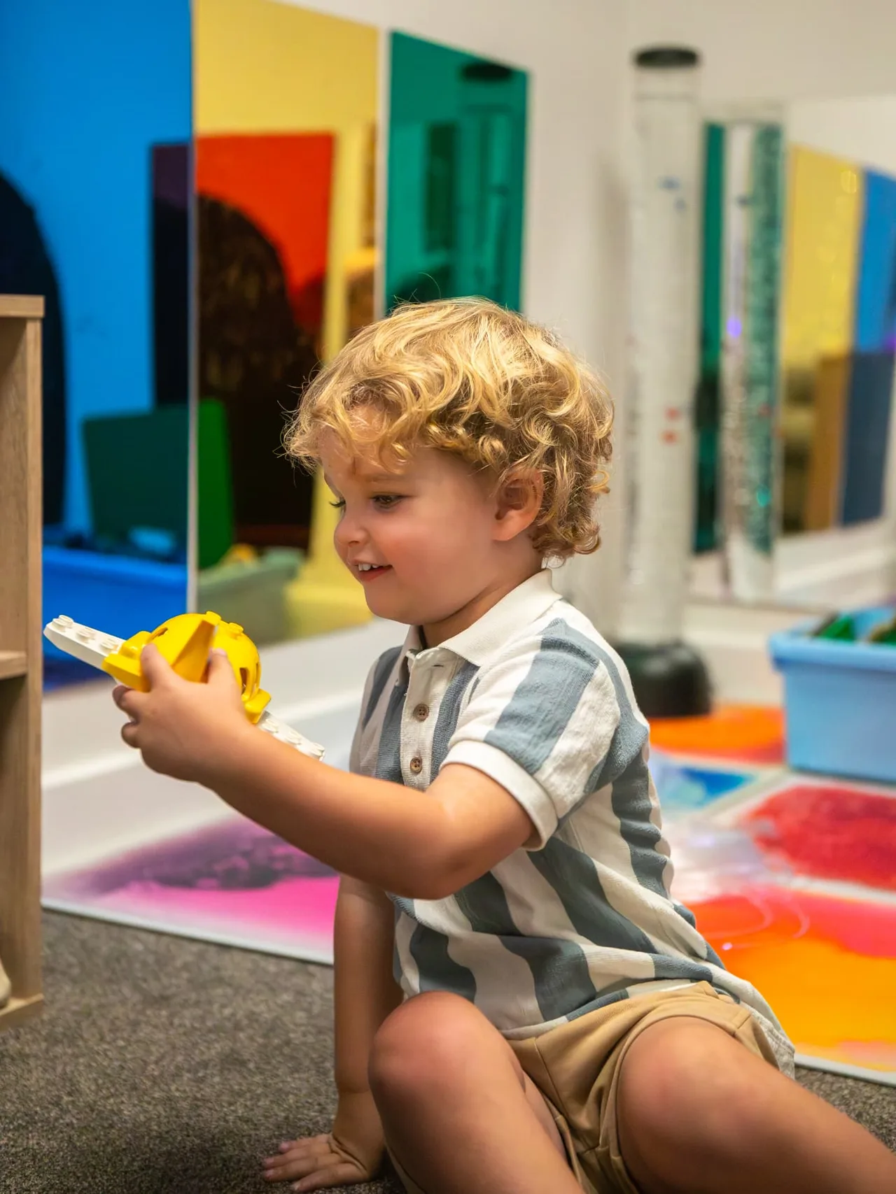 A toddler concentrating on a toy drill at the tuff tray