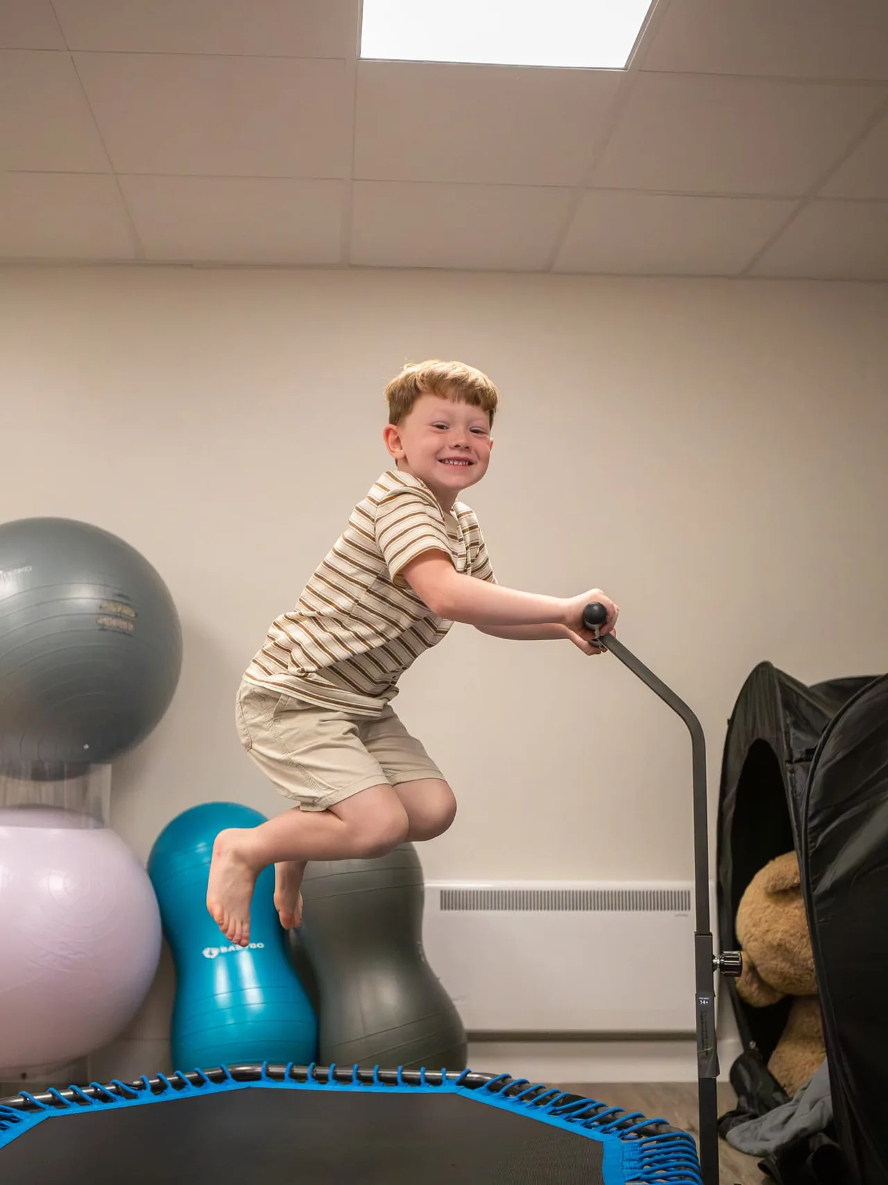 A boy bouncing on the small trampoline in the soft play room
