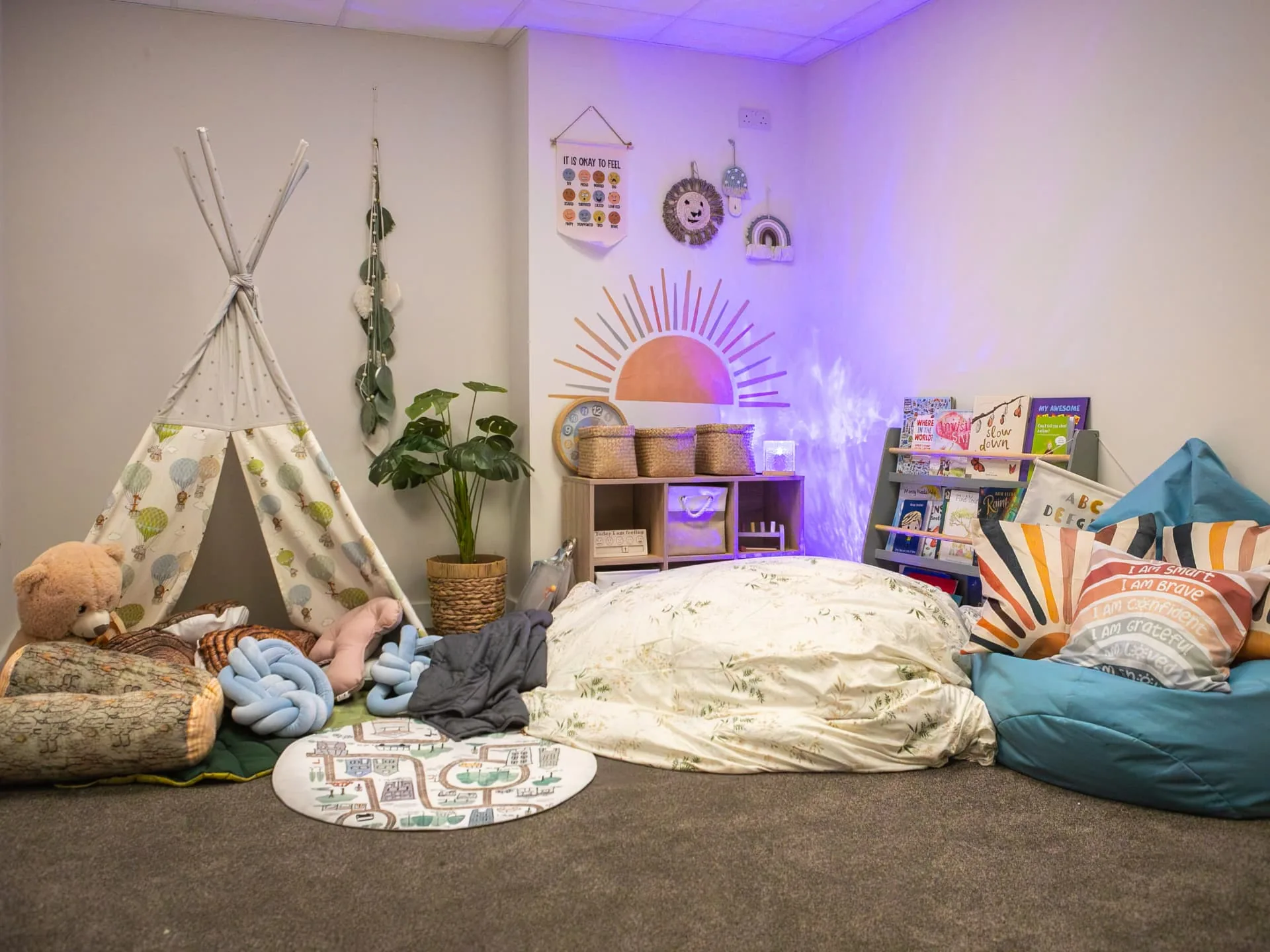 The Connect sensory room with a teepee, beanbags, soft purple lighting and a bookshelf