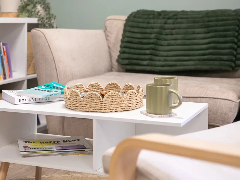 Books, a woven basket and mugs on the coffee table in the Connect therapy room